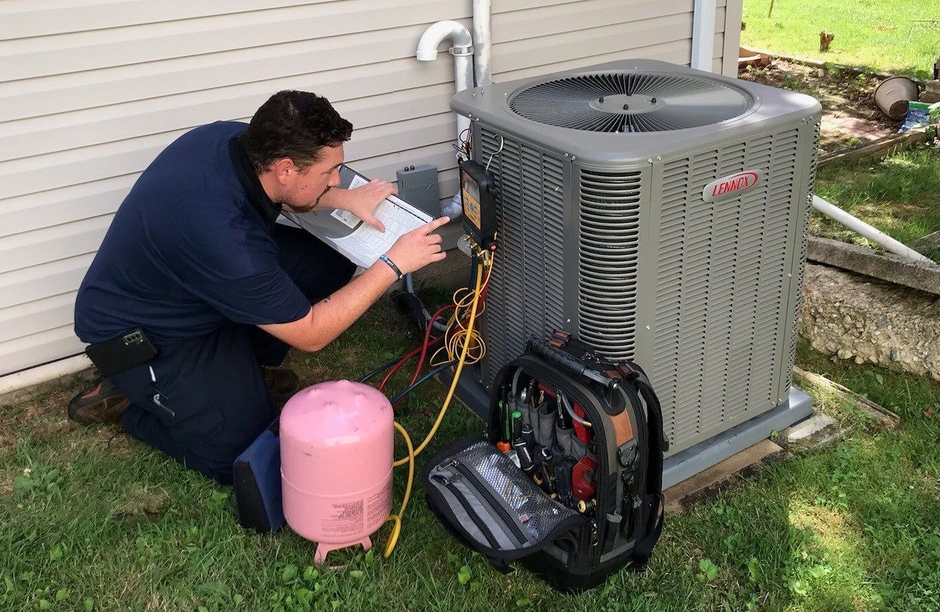 HVAC technician checking a system with diagnostic gauges