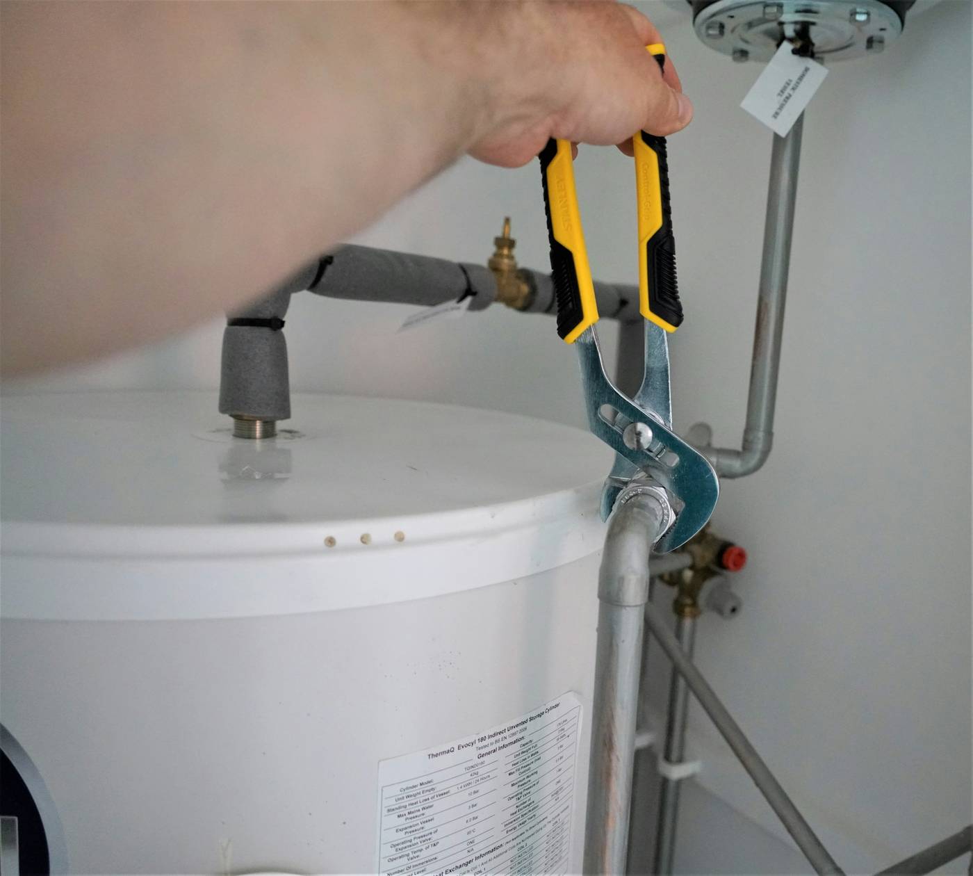 Plumber tightening a fitting on a residential water heater